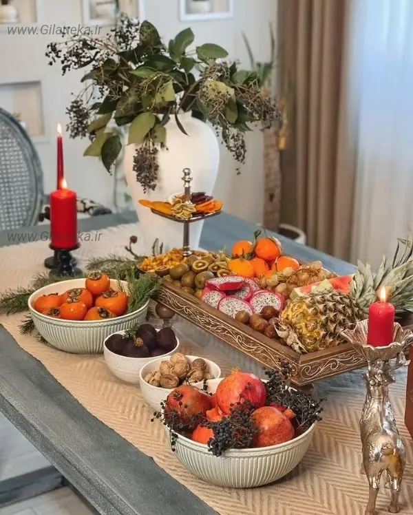 میز یلدا با چیدمان میوه انار لبو گردو خرمالو شمع و گل و آجیل یلدا